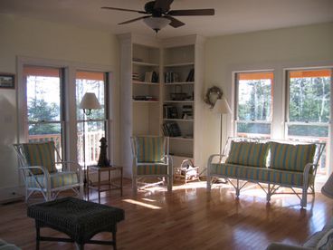 Sun-filled living room surrounded by windows.